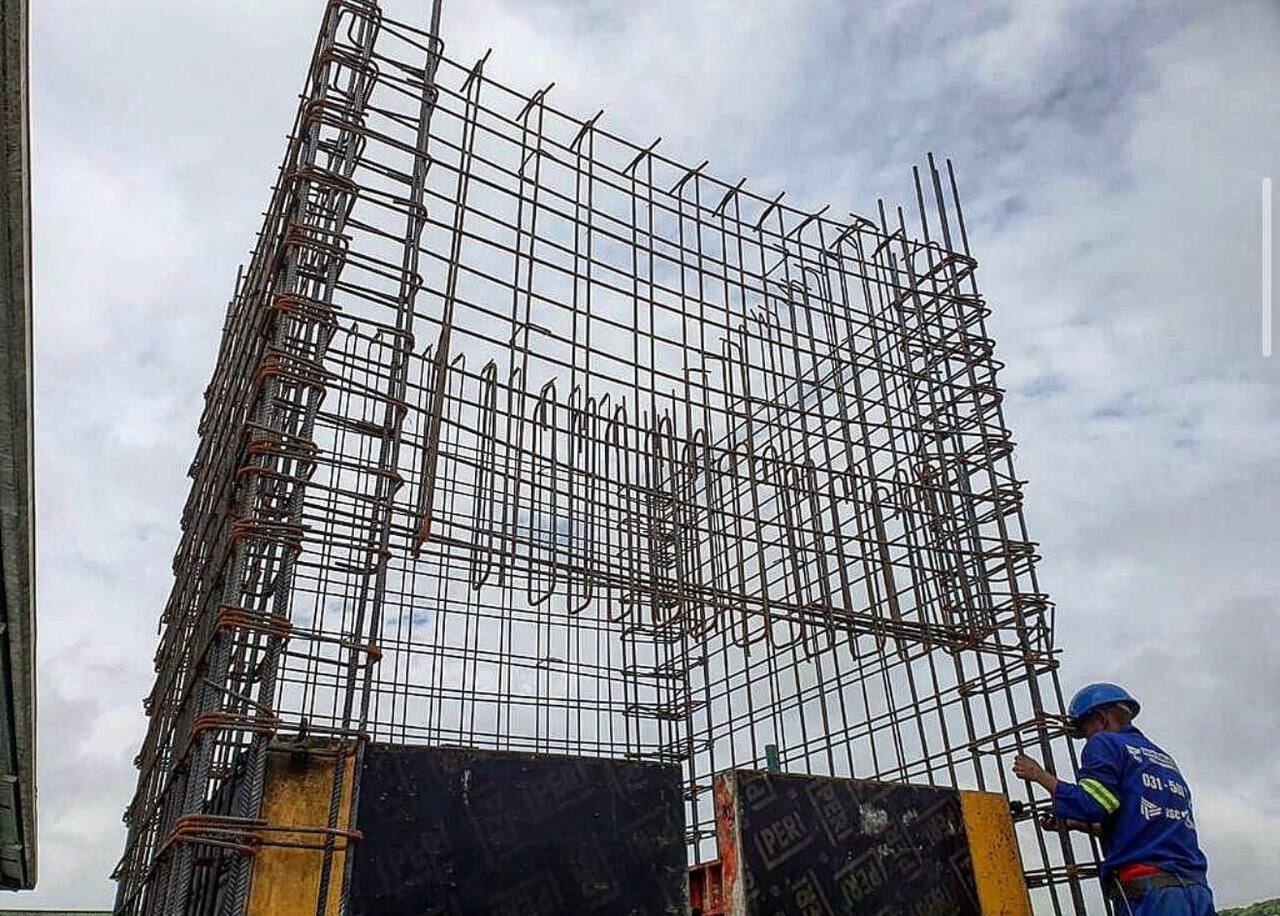 Large reinforcing steel rebar cage being assembled on site by a Deck, Steel & Concrete worker