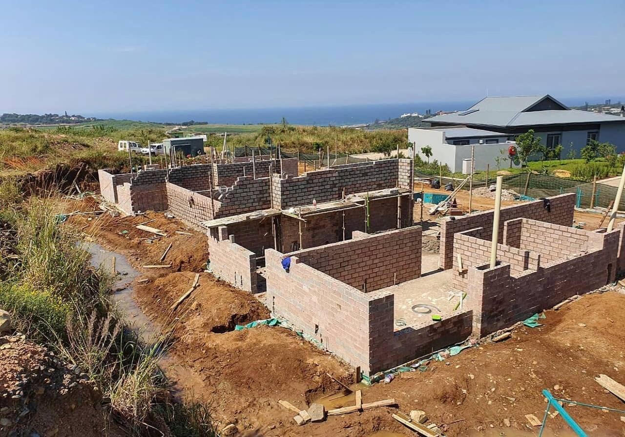 Brick blockwork walls under construction for a new house with sea views in the background