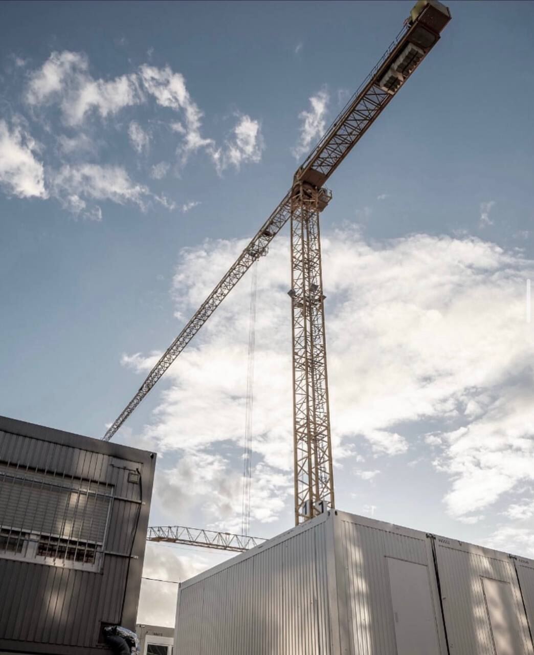 Tower crane against an evening sky at a Deck, Steel & Concrete project site